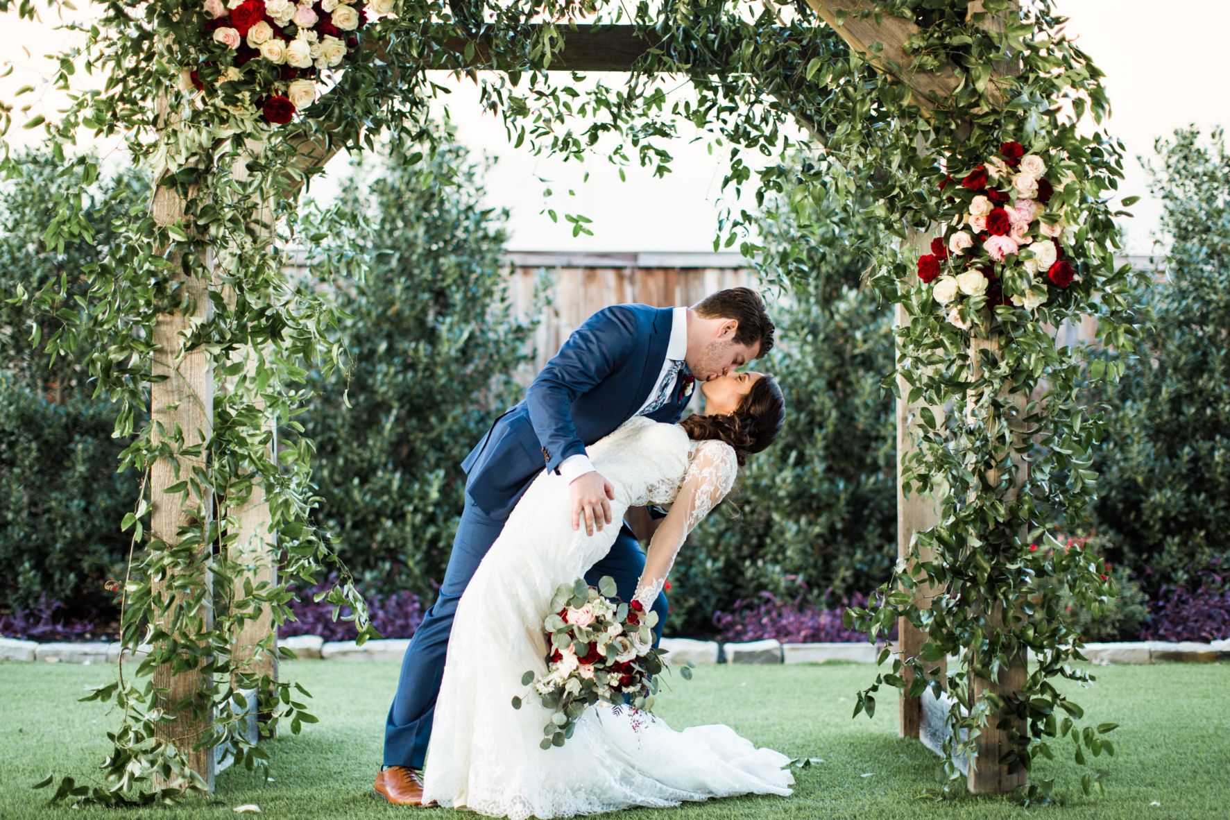 KP-011-rustic wedding-outdoor wedding-wedding arch-red wedding-bride-groom-wedding kiss-JudyCordellEvents